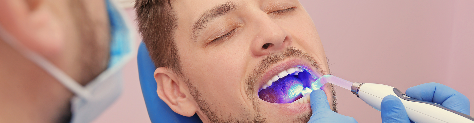 dentist hardening filling material with light in patient's mouth