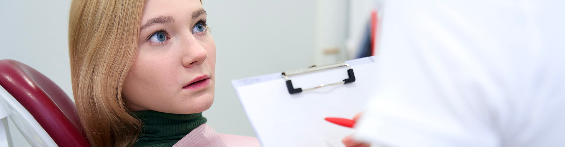 woman staring fearfully at a dentist
