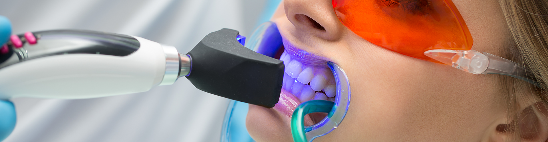 woman with led light whitening her teeth