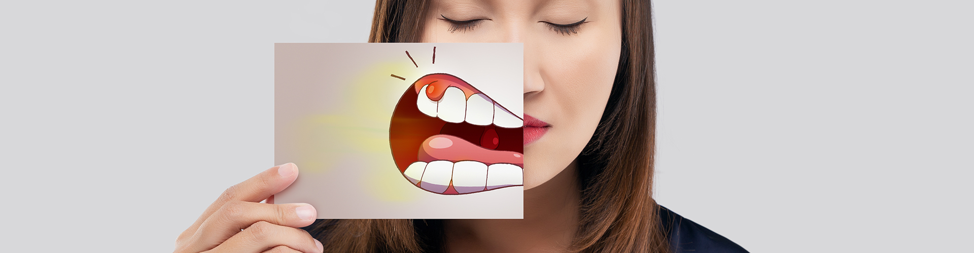 woman holding dental abscess illustration in front of mouth