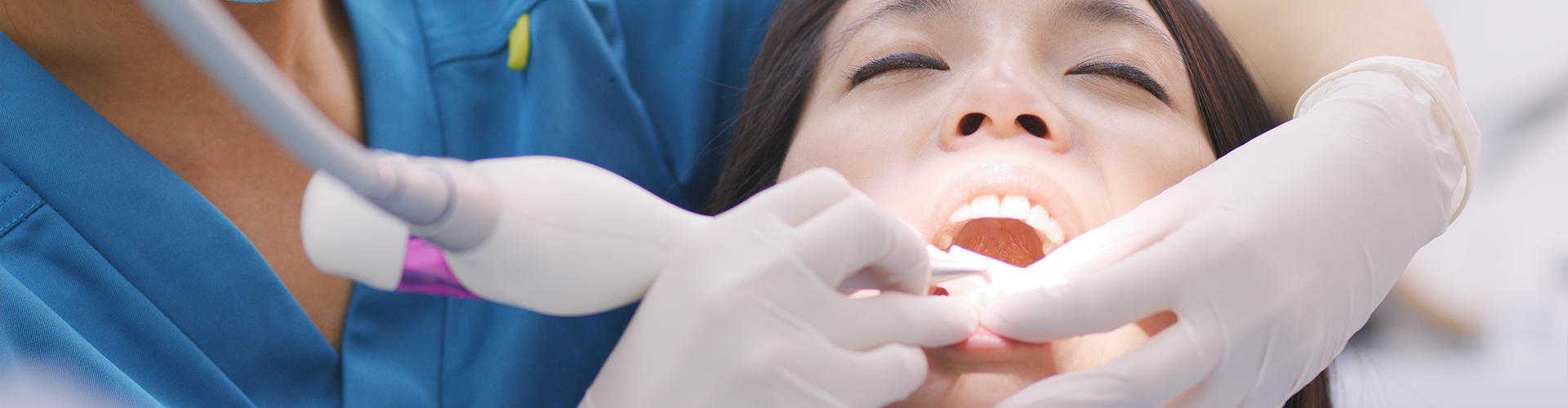 dentist using dental tool in patient's mouth