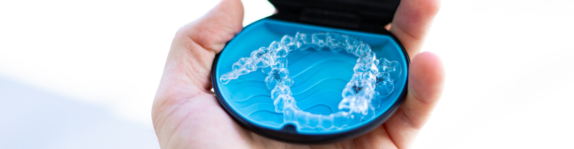hand holding an opened Invisalign case